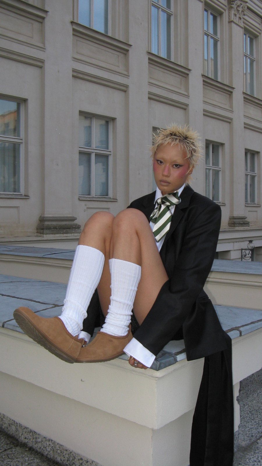 Streetstyle portrait seated outside, wearing boots