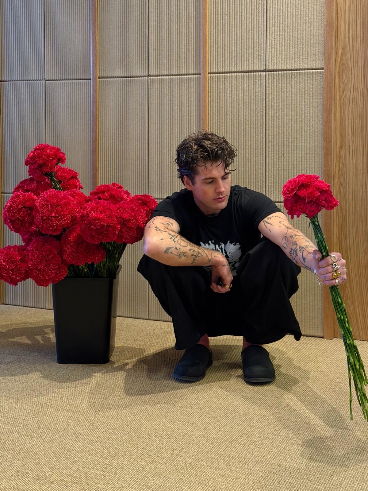 Artist portrait framed by red flowers